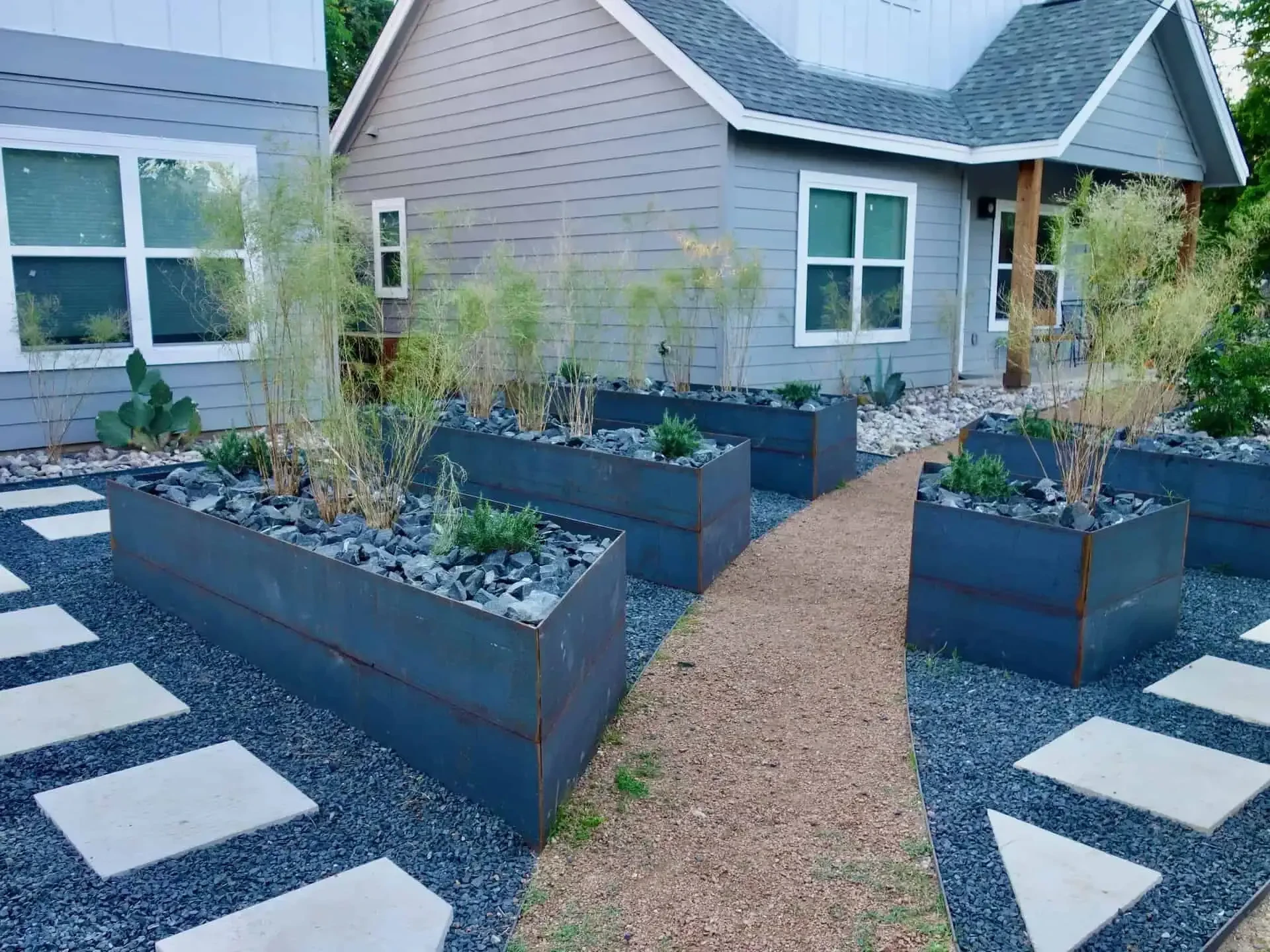 Modern xeriscape with steel planters and LED lighting Mueller Austin TX
