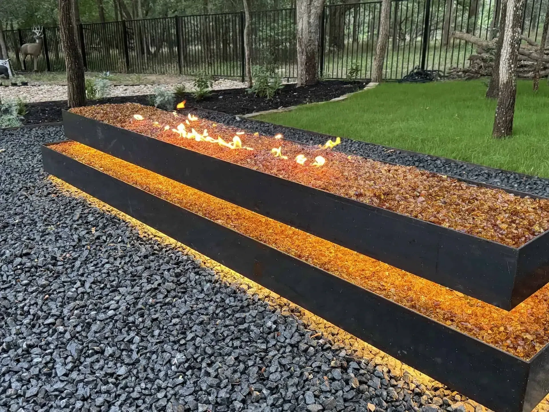 1,800 sq ft marbled concrete patio with 1/4-inch steel edging and floating boulder fire pit — Lakeway Austin TX
