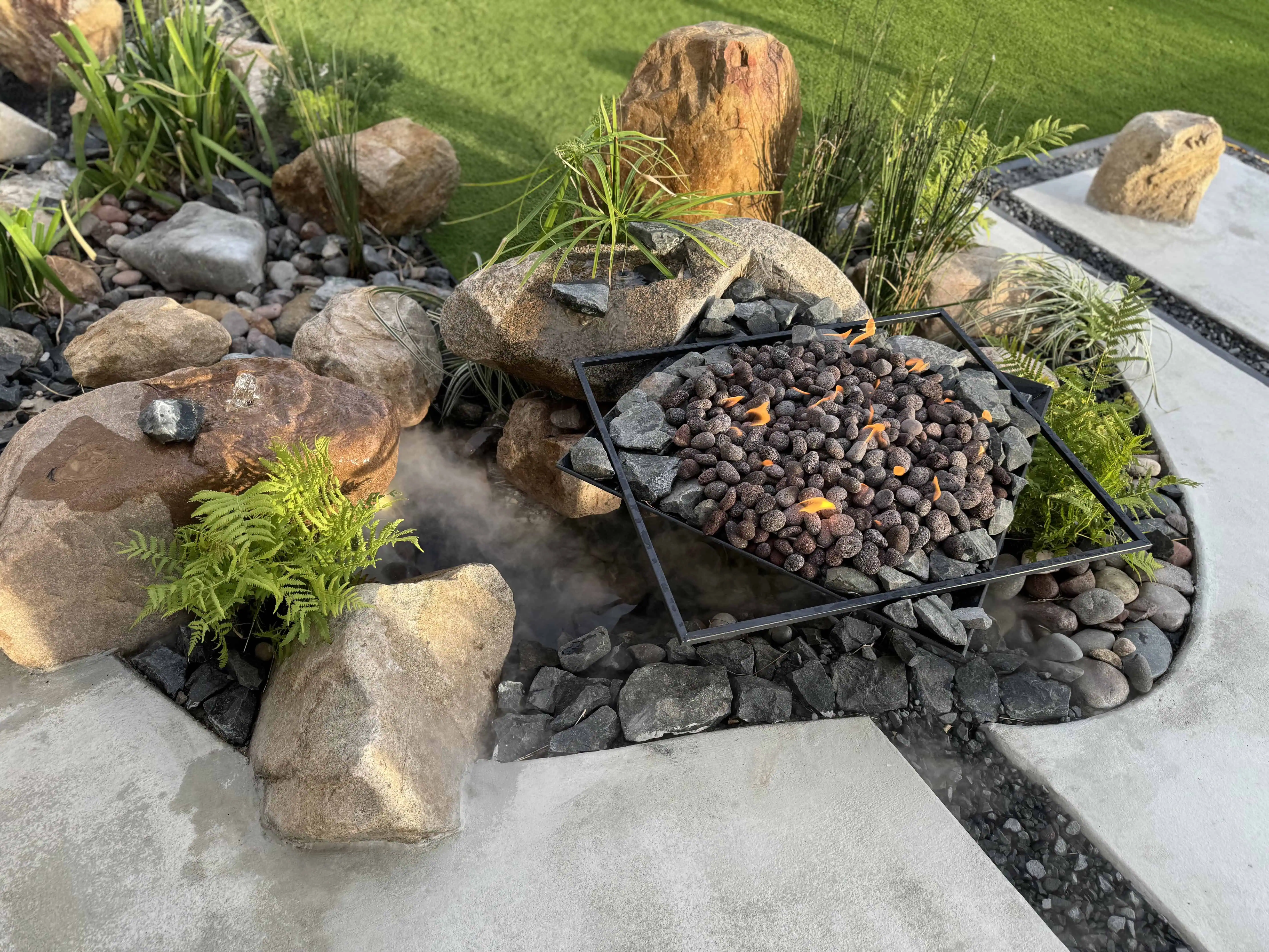 Fire pit overhead with volcanic rock, boulder fountain mist, ferns and boulders — Pflugerville TX