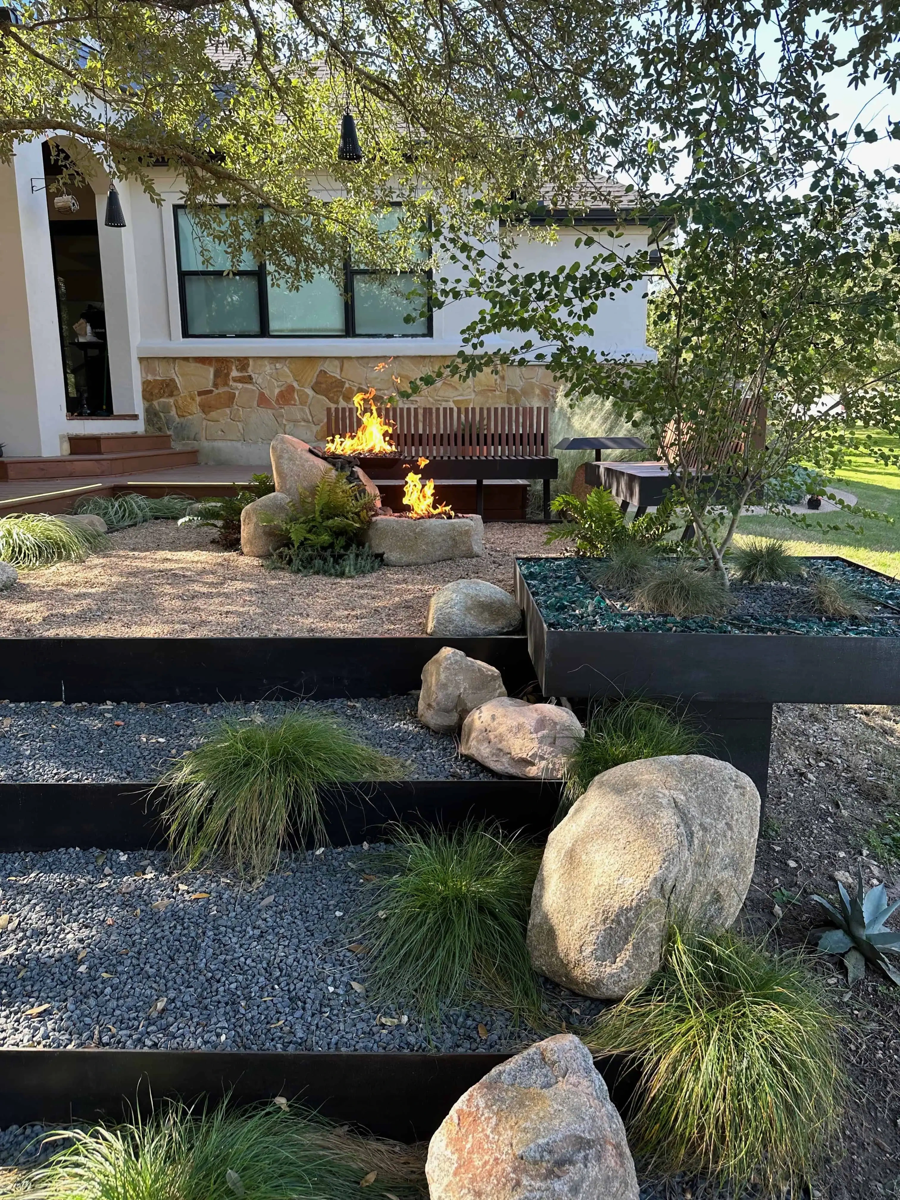 Blazyk — steel terraces, dual fire features, turquoise glass planters — Circle C Austin TX