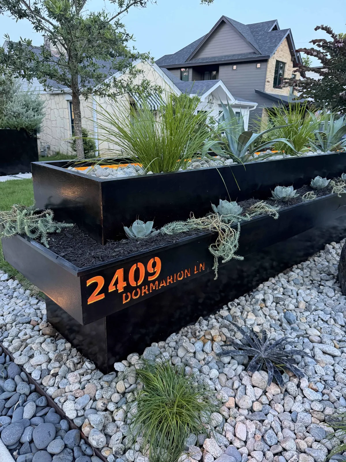 CNC address sign with copper backing glowing at dusk, cantilevered planter with agave and sedum — Tarrytown Austin TX