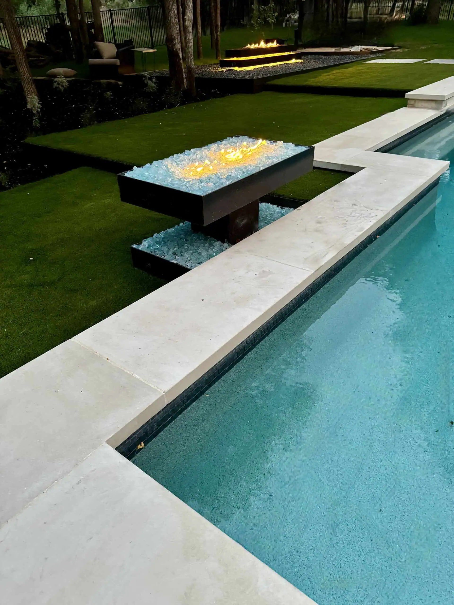 Pool coping with both welded steel fire pits visible — Austin TX
