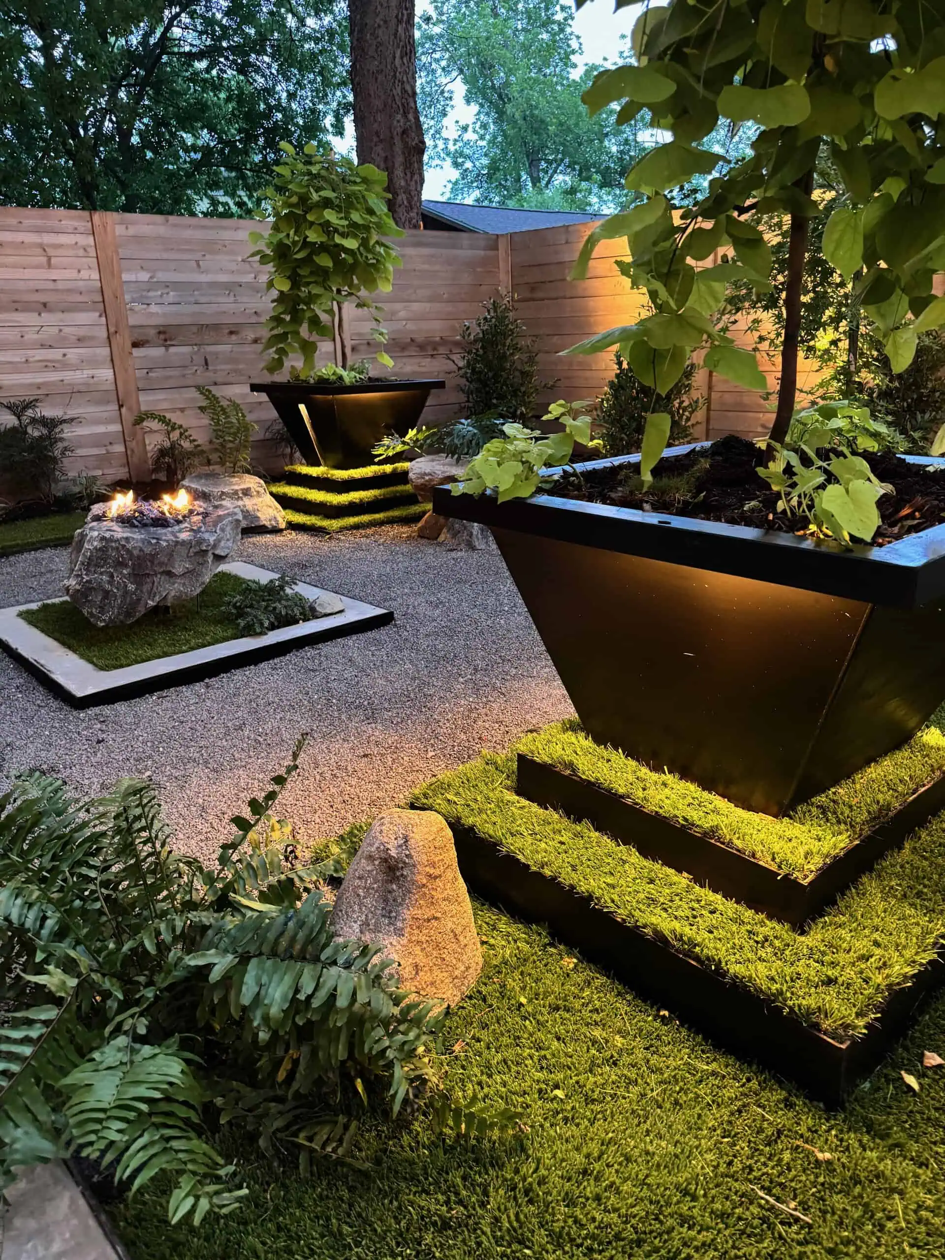 Madison after — terraced Ultra Real turf, black diamond boulder fire pit and bench, COB lighting — Austin TX