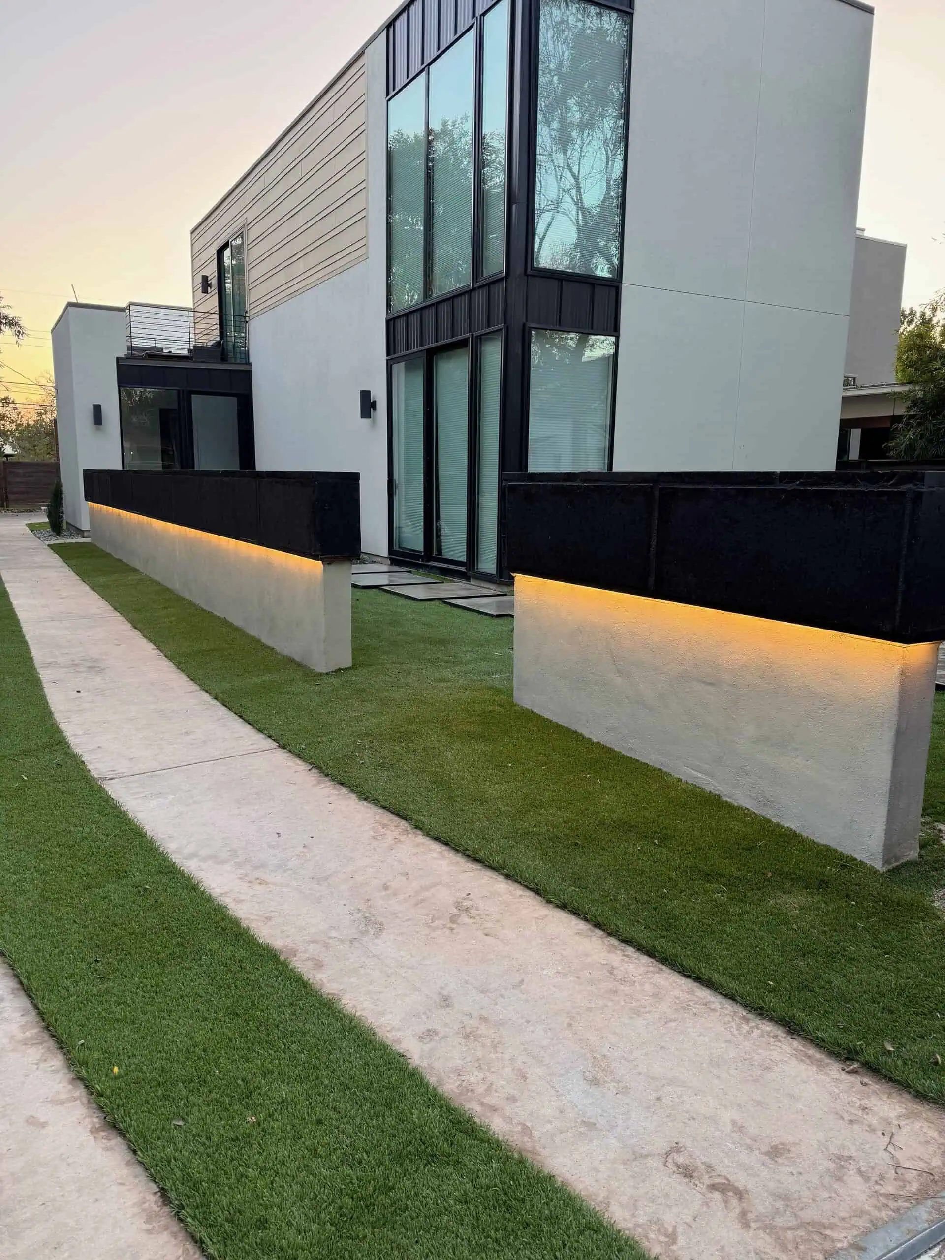 Black cantera wall on angle steel ledge with COB lighting underneath — Austin TX